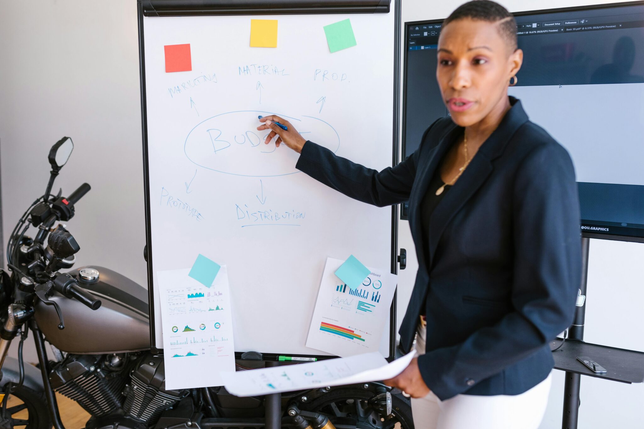 Confident businesswoman presenting a marketing strategy on a whiteboard in a modern office setting.